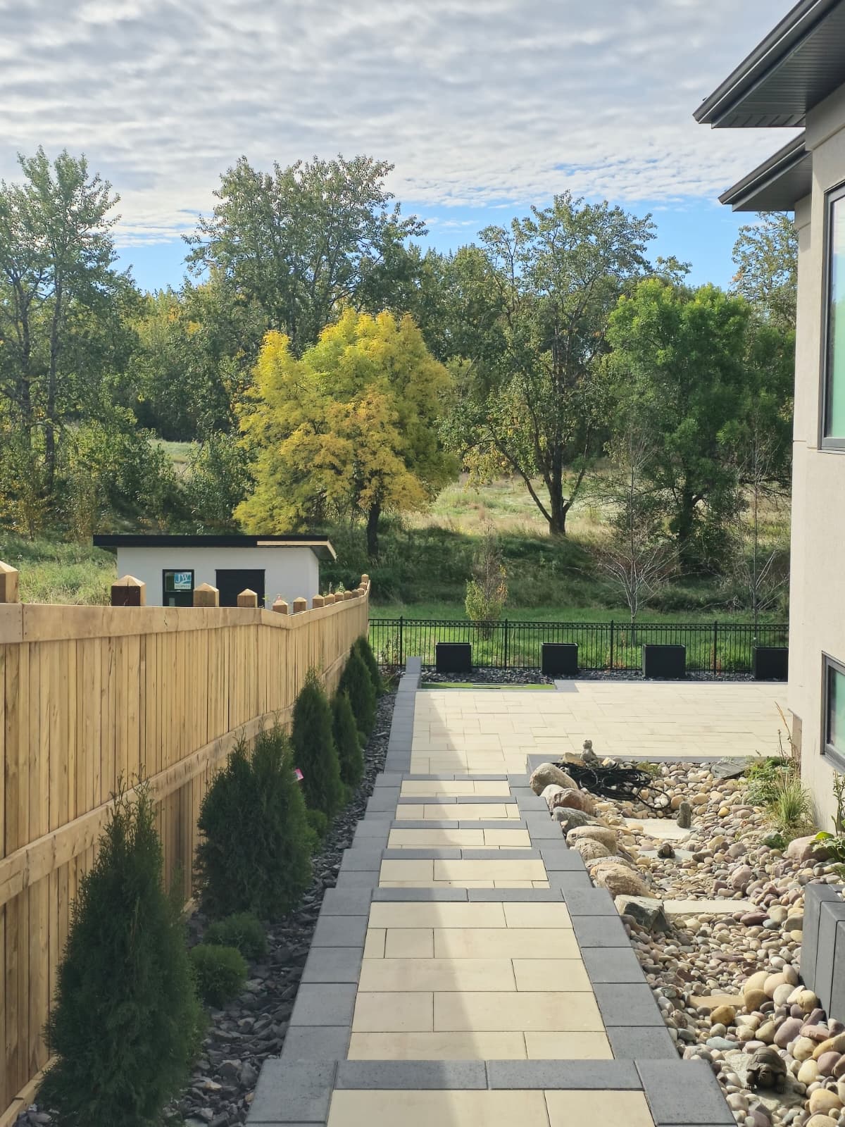 Paver walkway with river rock along modern home — Edmonton