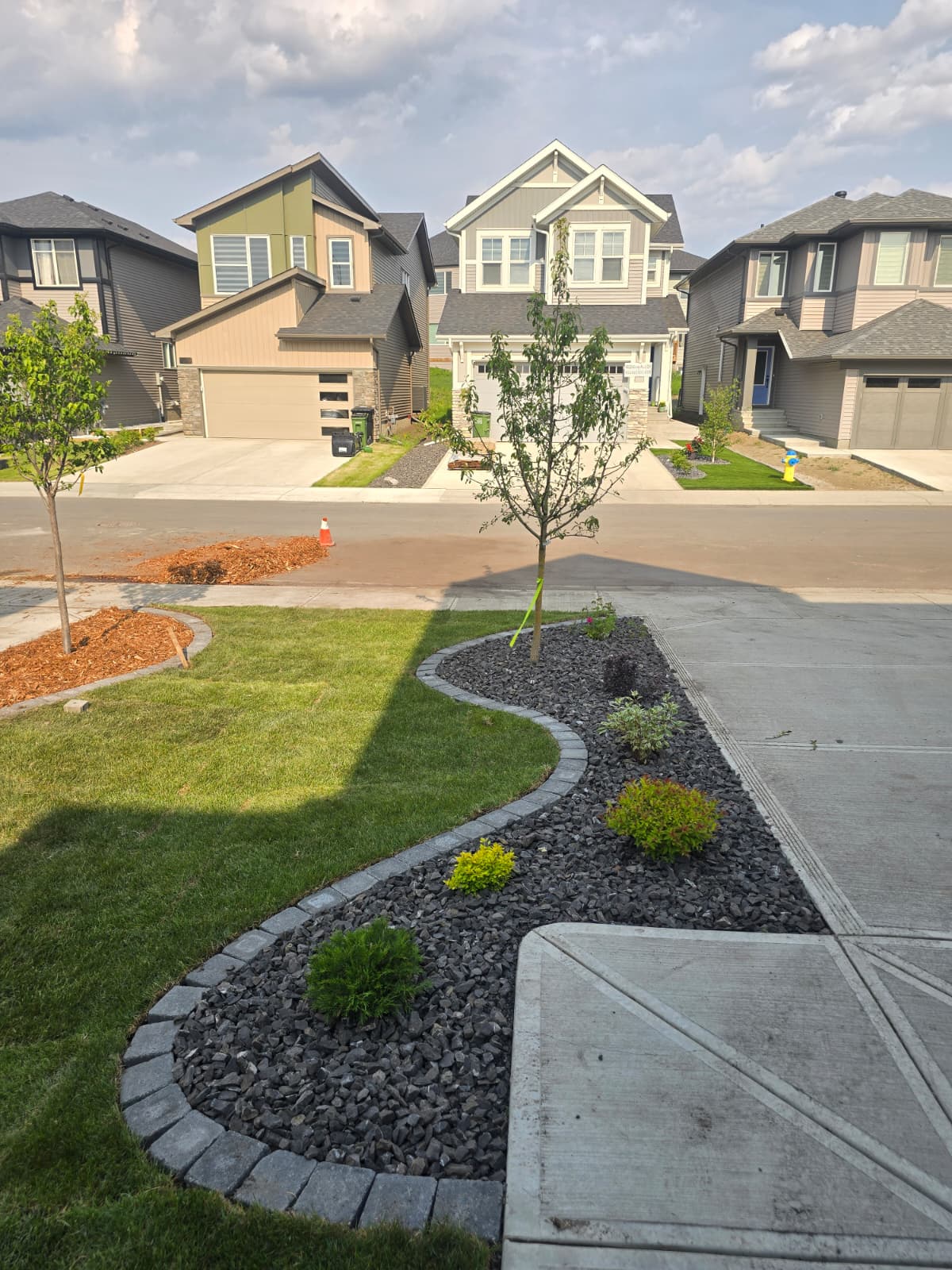 Fresh sod with curved crushed rock bed along driveway — Edmonton