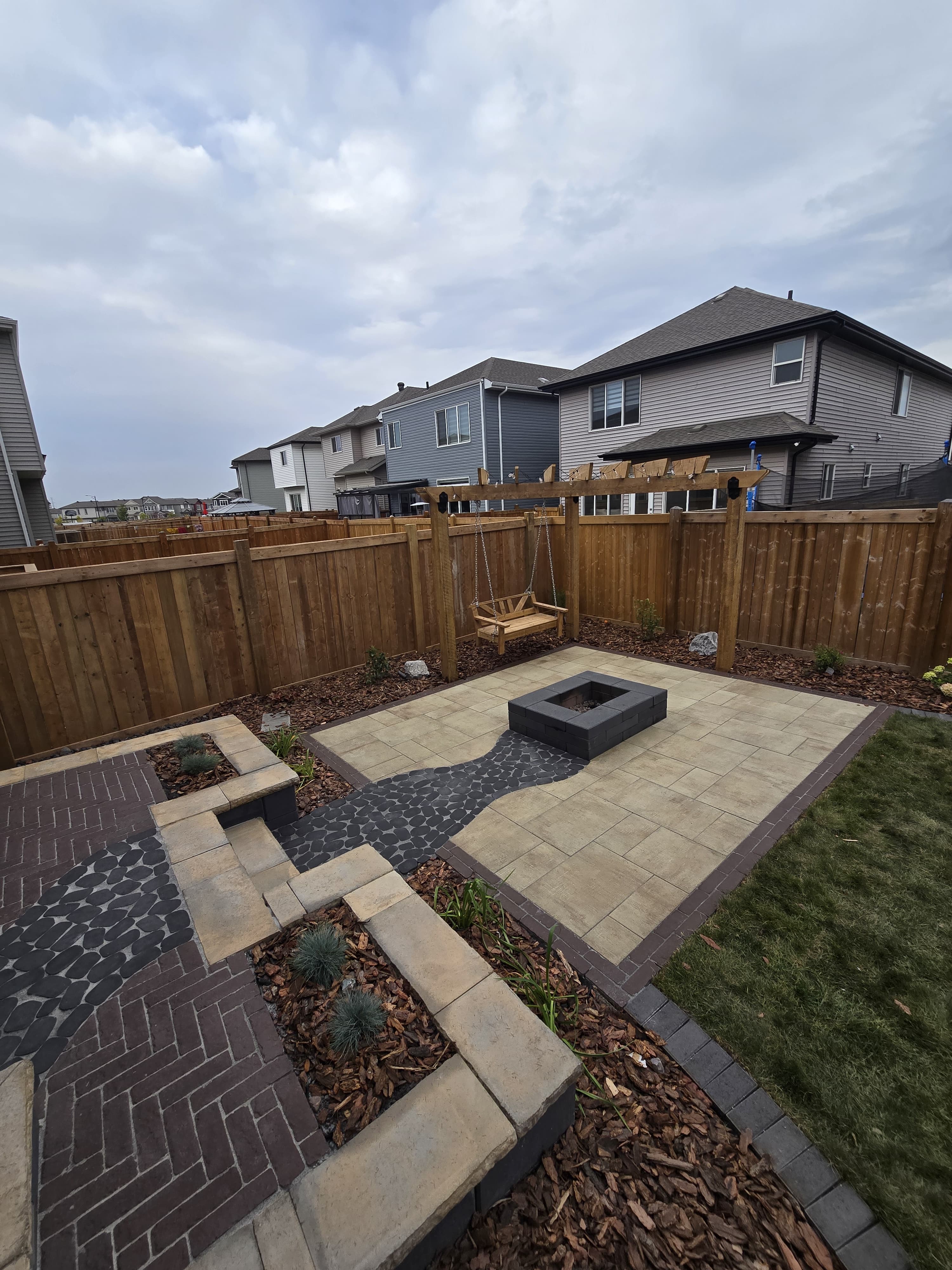 Square stone firepit patio with raised border — Edmonton