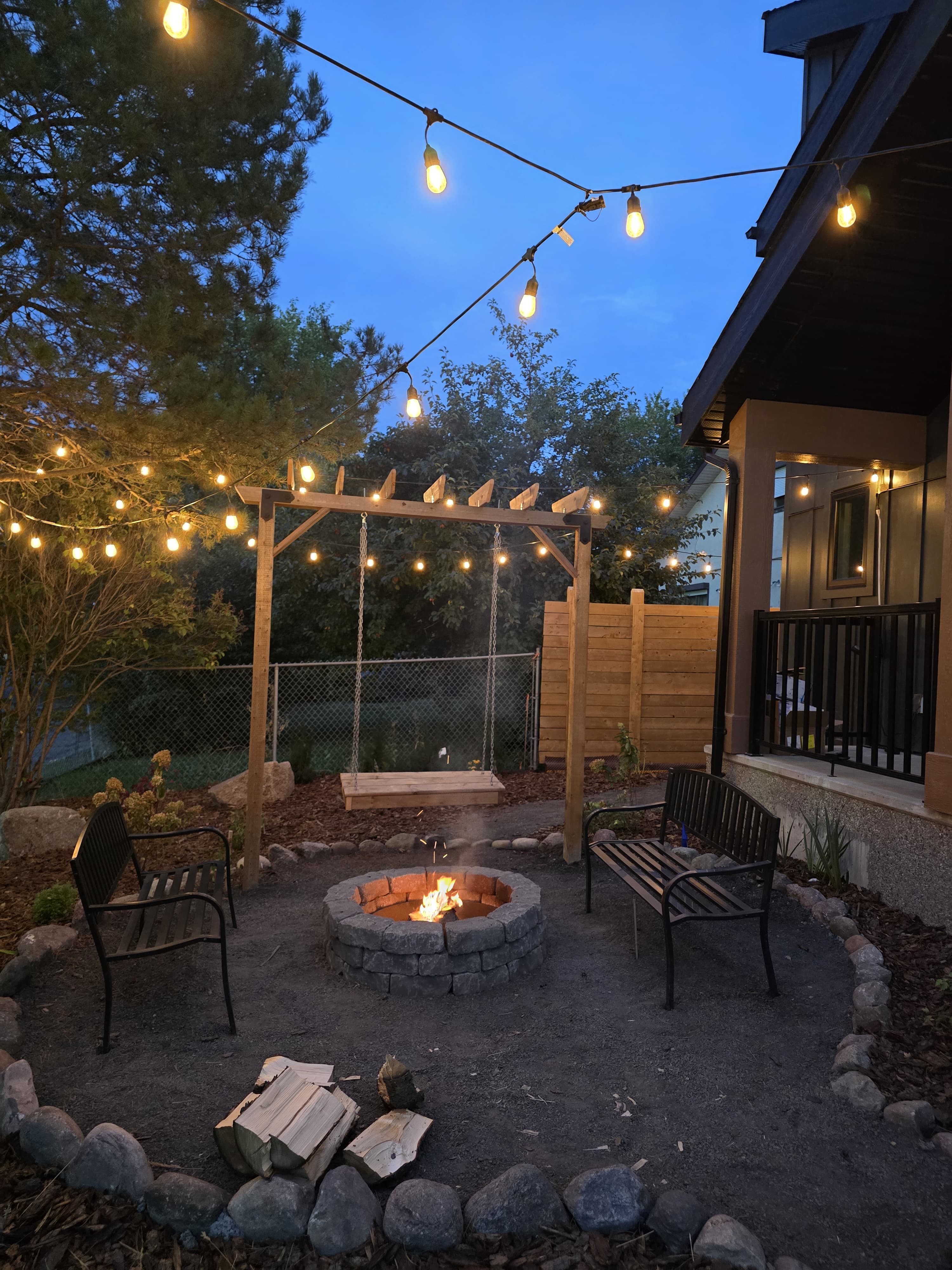 Pergola with swing and fire pit at dusk — Edmonton