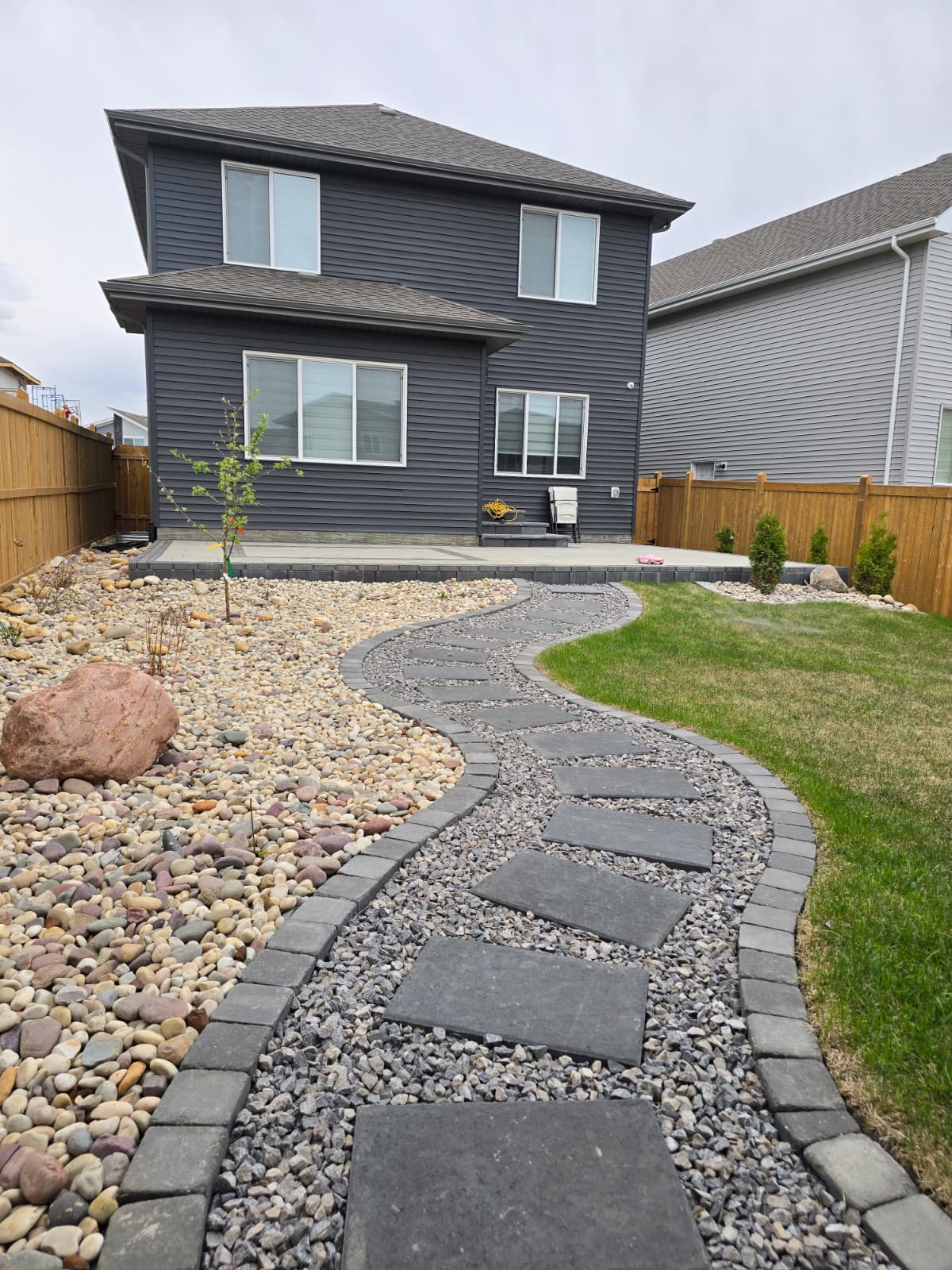 Backyard rockscape with stone steppers — Spruce Grove